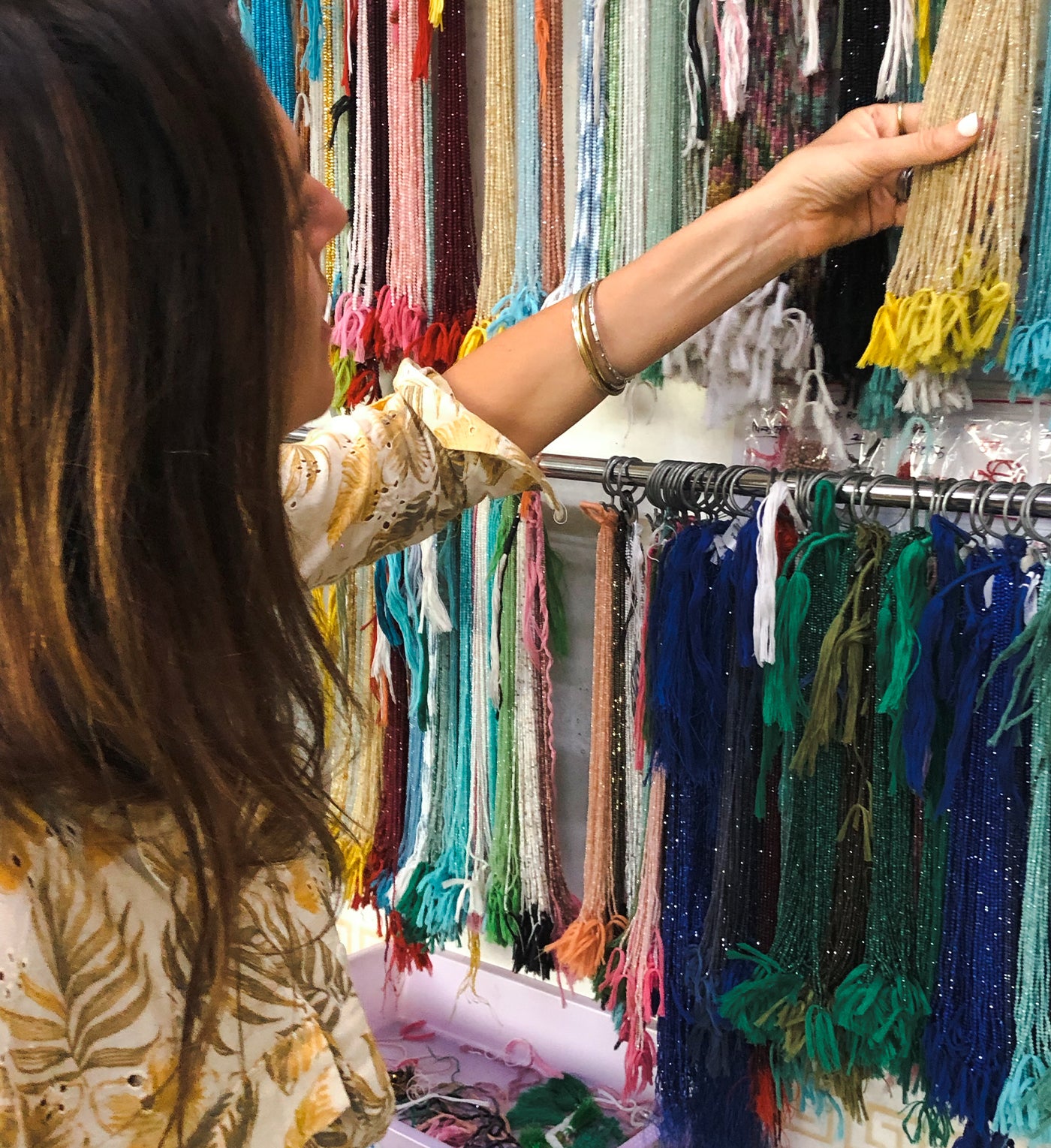 Woman traveler admiring a beautiful collection of beads in a store