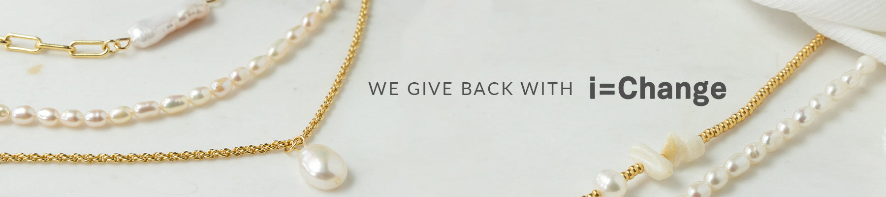 Three Arms Of Eve pearl necklaces with the words 'we give back' and 'i = change'